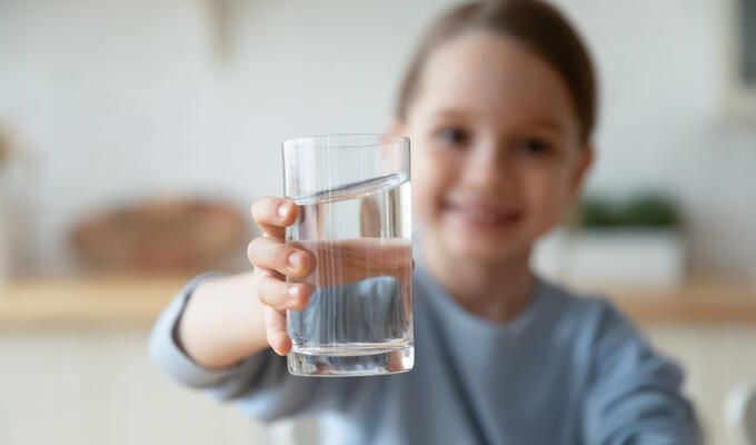 Girl holds clear glass of water