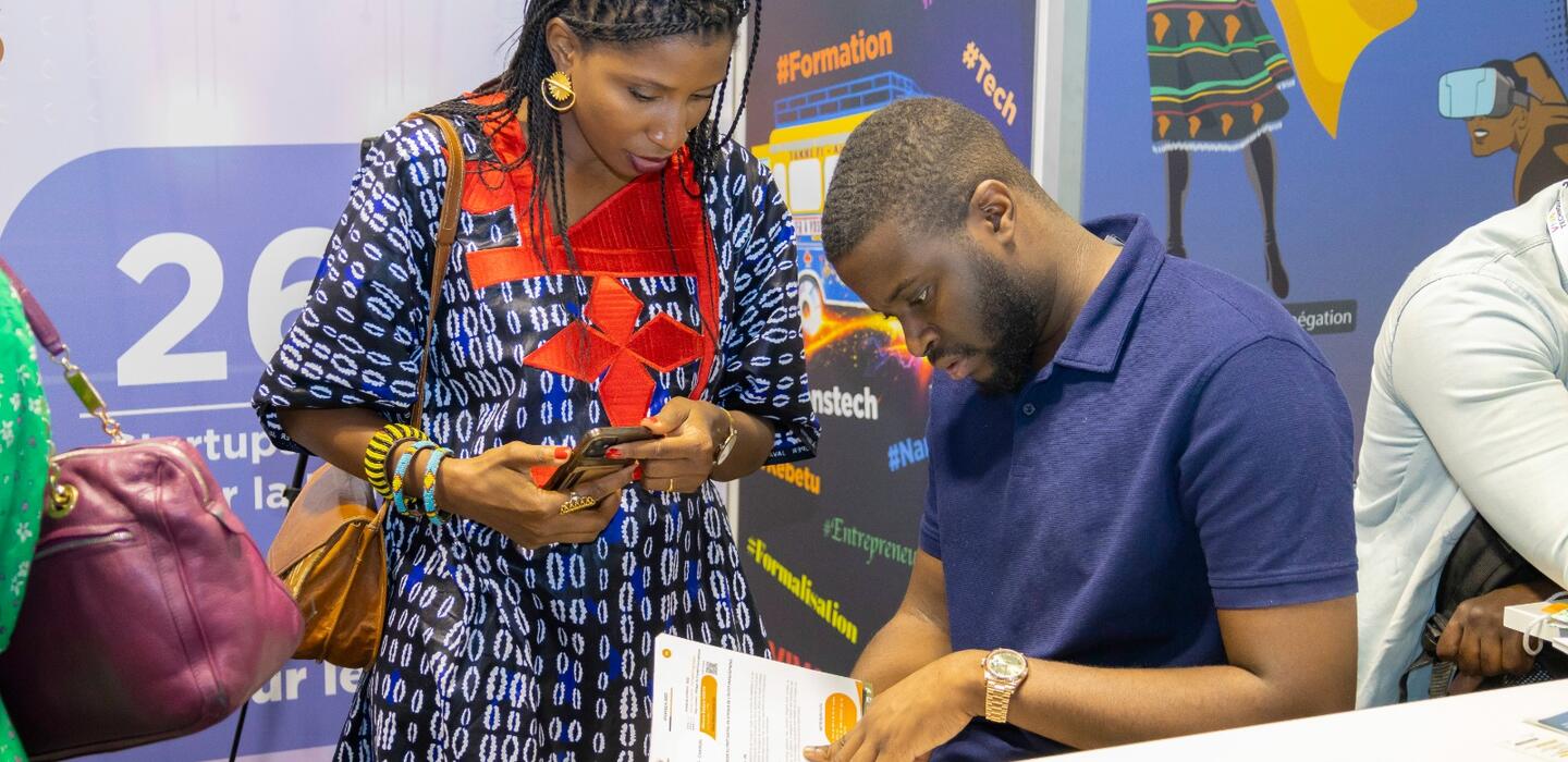 Senegalese woman speaks with man at tech expo
