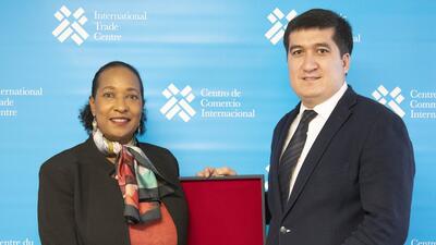 Azizbek Urunov, Chief Negotiator of Uzbekistan's accession to the WTO, holds a box with ITC Executive Director Pamela Coke-Hamilton.