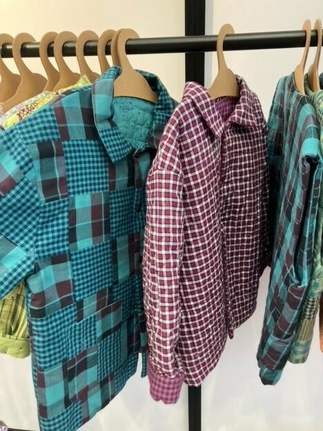 Colourful shirts line a rack