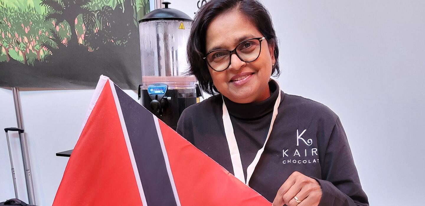 Una mujer sostiene la bandera nacional de Trinidad y Tobago