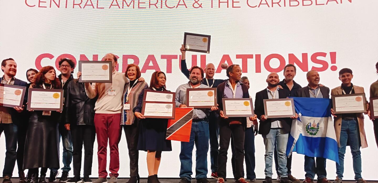Unos emprendedores sostienen los certificados de ganadores en el escenario