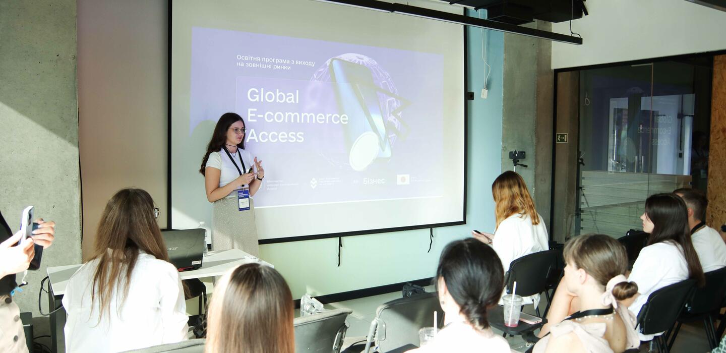 Woman stands near screen to give ecommerce presentation in Ukraine